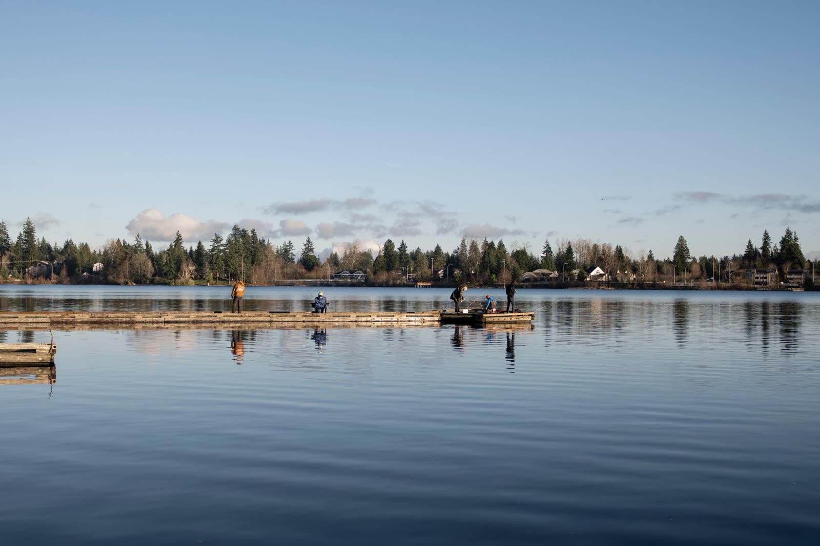 people sitting on a lakeside dock on a calm autumn morning / satellite view of a calm Atlantic Ocean and Gulf / rain clouds building over a wide Southern river in autumn